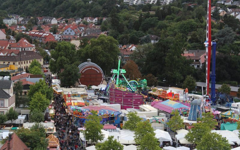 Aerial view of the Dürkheimer Wurstmarkt fairground with the giant wine barrel among stalls and rides