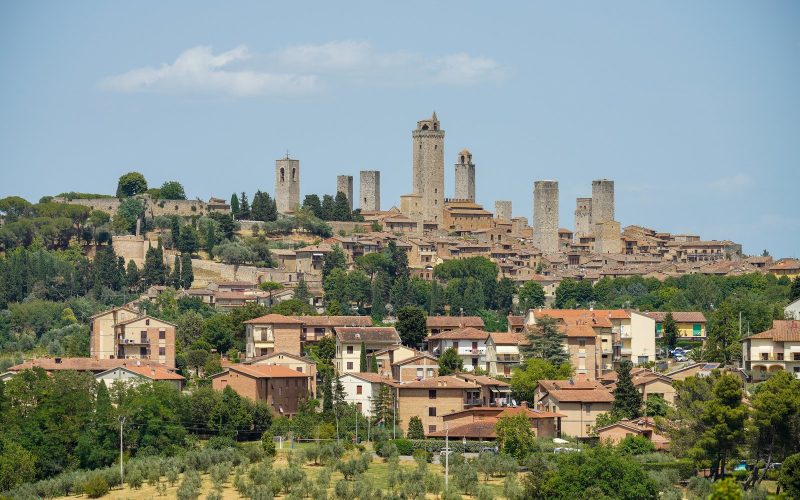 The medieval towers of San Gimignano above olive groves and rooftops in Tuscany