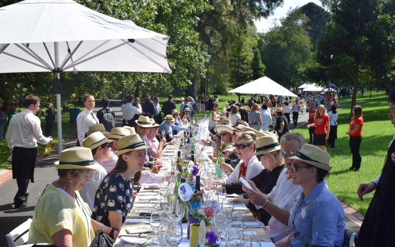 Guests seated at the World's Longest Lunch table in a Melbourne park