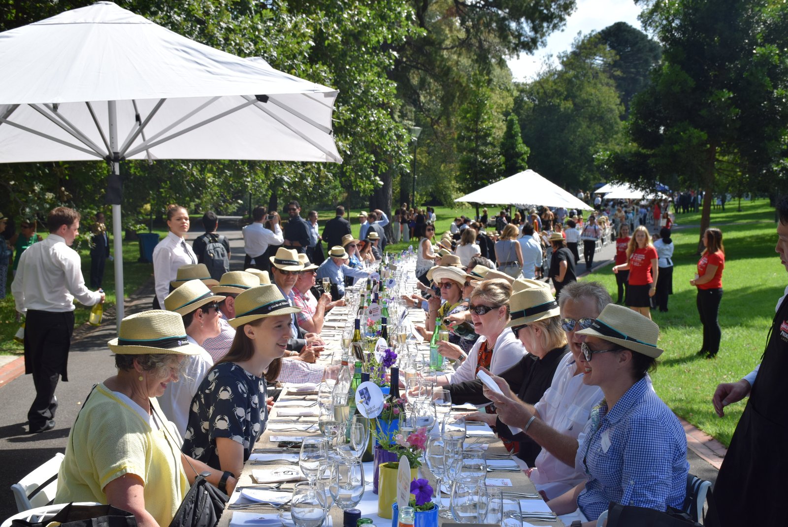 Guests seated at the World's Longest Lunch table in a Melbourne park