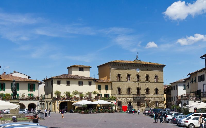 Triangular Piazza Matteotti with arcades and café umbrellas in Greve in Chianti