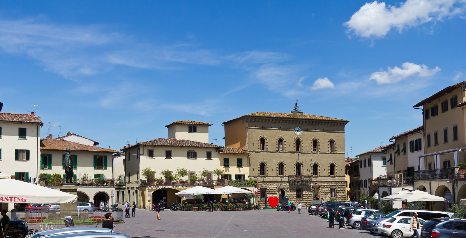 Triangular Piazza Matteotti with arcades and café umbrellas in Greve in Chianti