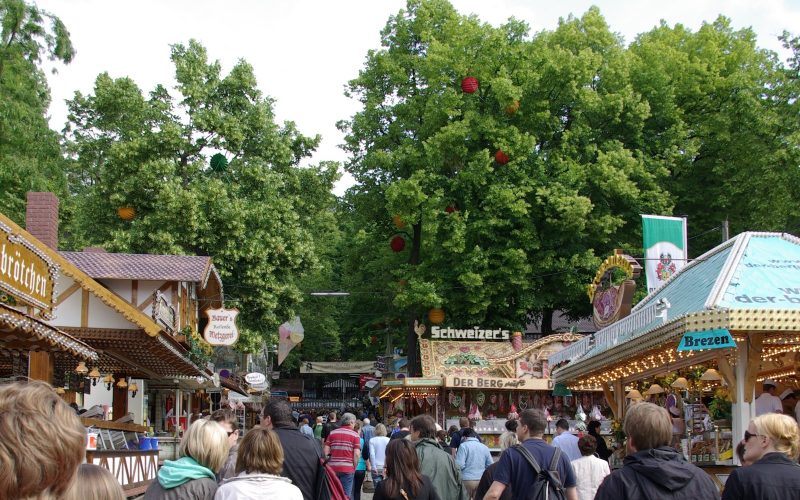 Fairground stalls and crowds under big trees at the Erlanger Bergkirchweih