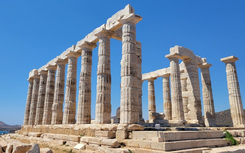 Doric columns of the Temple of Poseidon at Cape Sounion against a deep blue sky