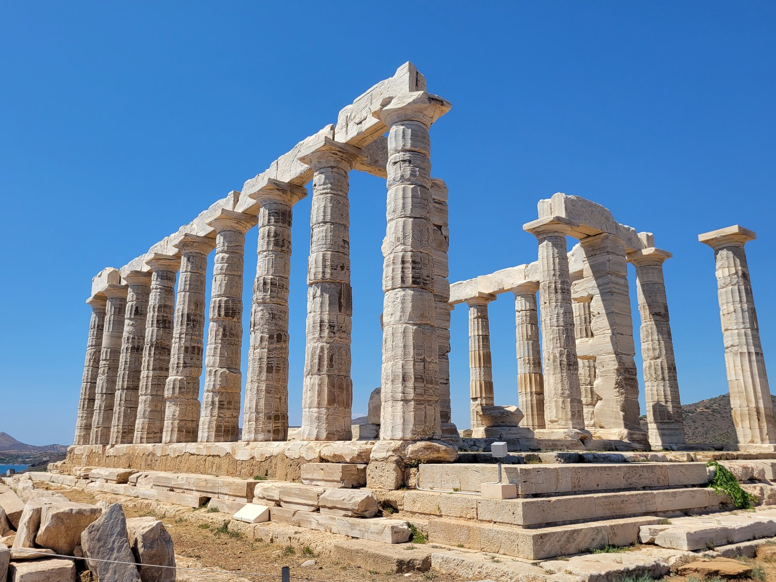 Doric columns of the Temple of Poseidon at Cape Sounion against a deep blue sky