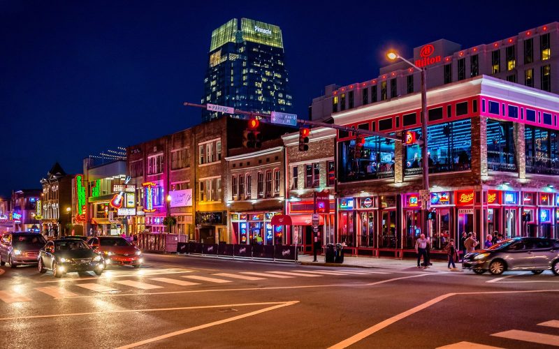 Neon-lit honky-tonks and restaurants on Broadway in downtown Nashville at night