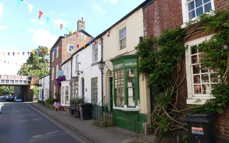 Bunting and ivy-covered brick cottages on King Street, Knutsford