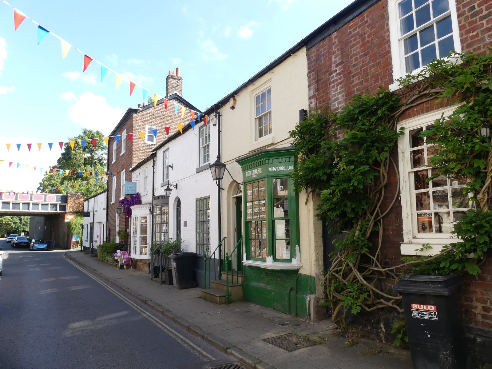 Bunting and ivy-covered brick cottages on King Street, Knutsford