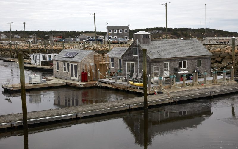 Weathered oyster shacks on floating docks in Wellfleet Harbor, Cape Cod