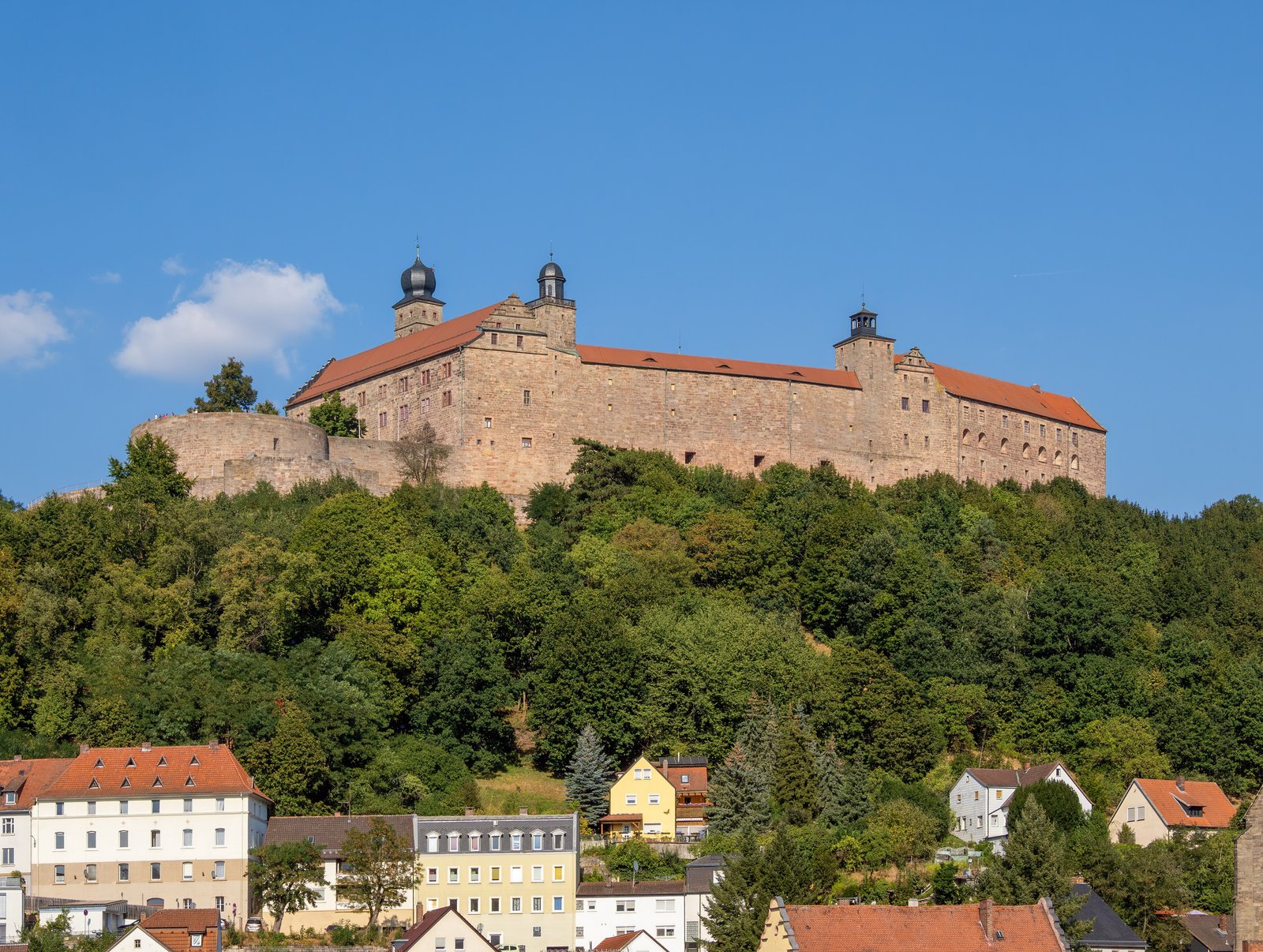 Plassenburg fortress above the rooftops of Kulmbach under a blue sky