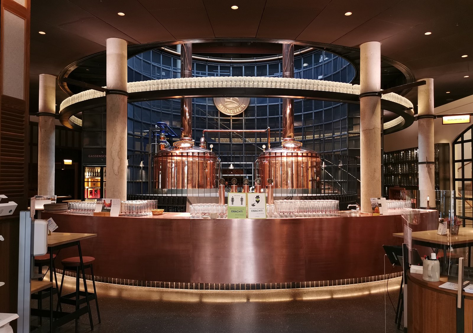Copper brewing kettles behind the round bar at Paulaner am Nockherberg in Munich