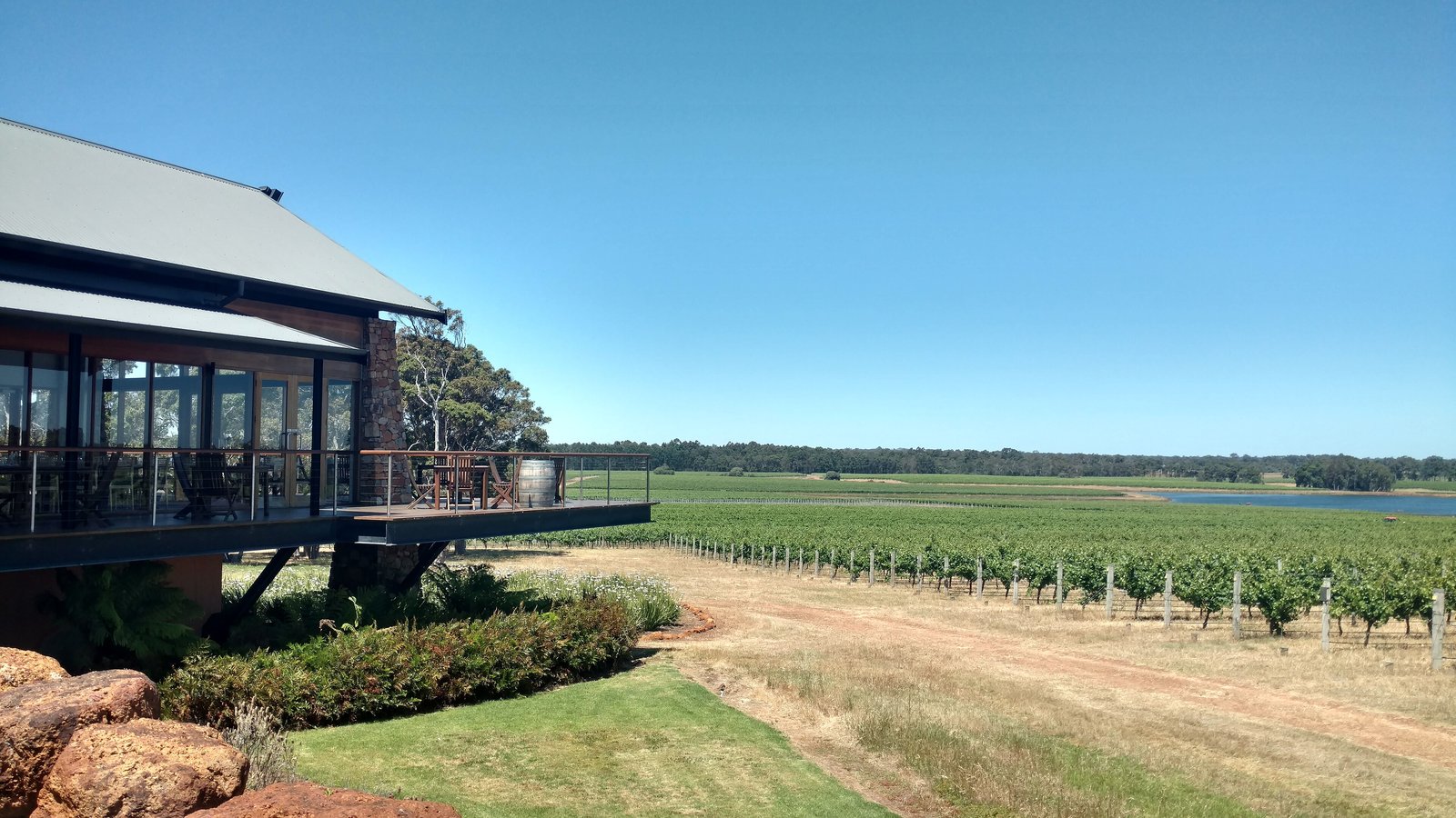 Winery terrace overlooking vineyard rows in Margaret River under a blue sky