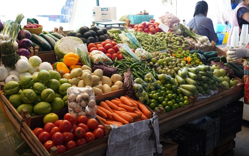 Market stall piled with fresh vegetables and limes in Oaxaca, Mexico