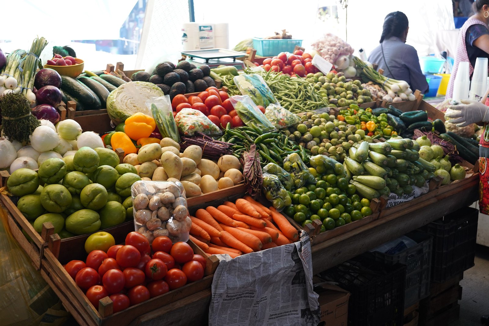 Market stall piled with fresh vegetables and limes in Oaxaca, Mexico