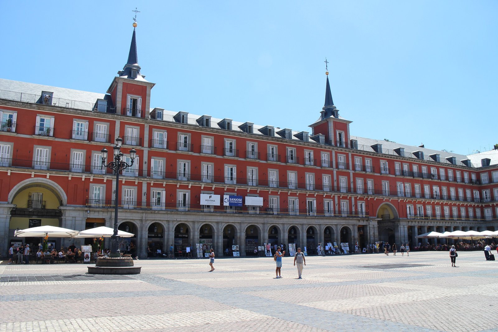 Plaza Mayor in Madrid with its red-fronted arcades under a clear sky