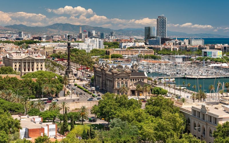 Barcelona harbour, Columbus monument and city rooftops with mountains beyond