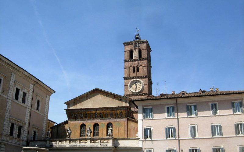 Santa Maria in Trastevere bell tower and ochre facades under a deep blue sky in Rome