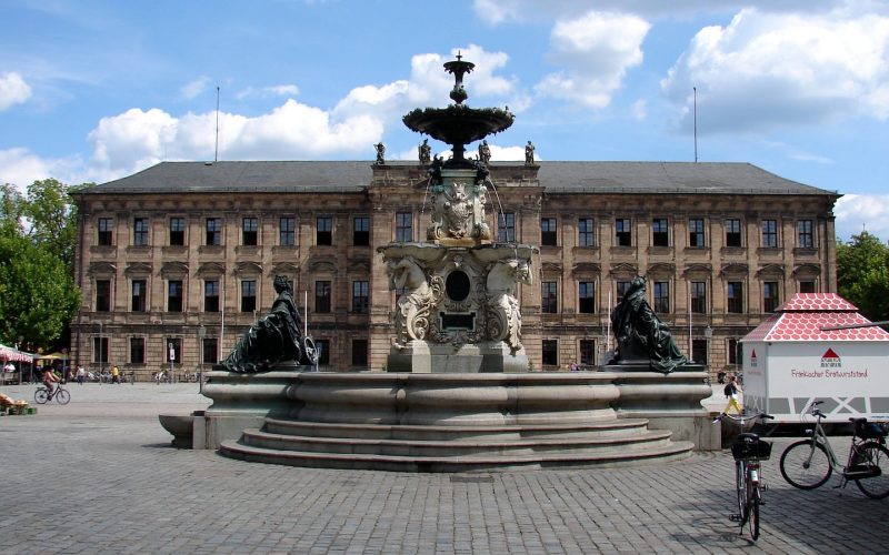 Erlangen Palace and the Paulibrunnen fountain on the Schlossplatz under a blue sky