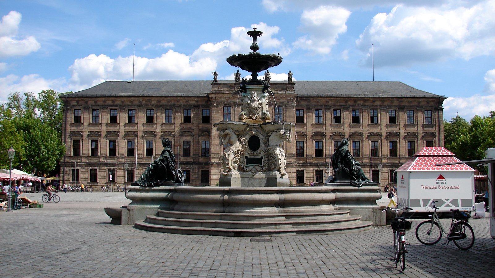 Erlangen Palace and the Paulibrunnen fountain on the Schlossplatz under a blue sky