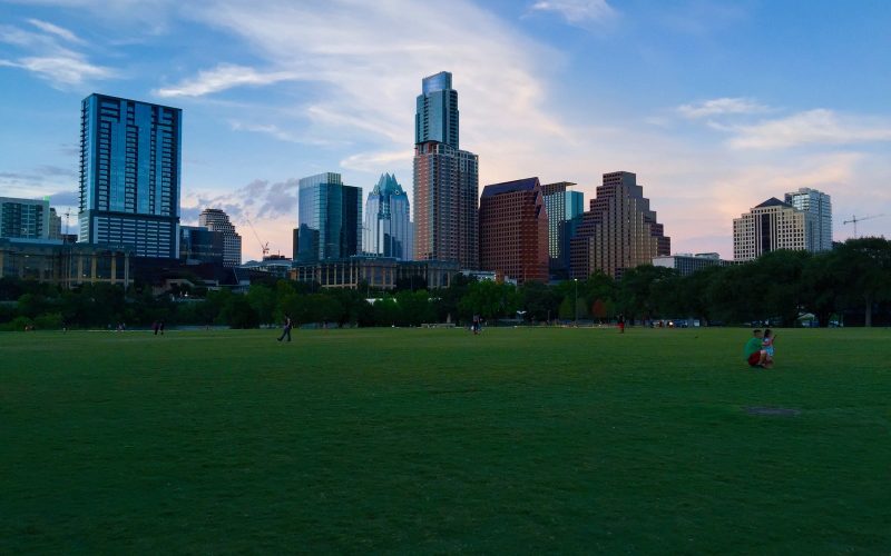Austin skyline at dusk seen across the lawn of Auditorium Shores