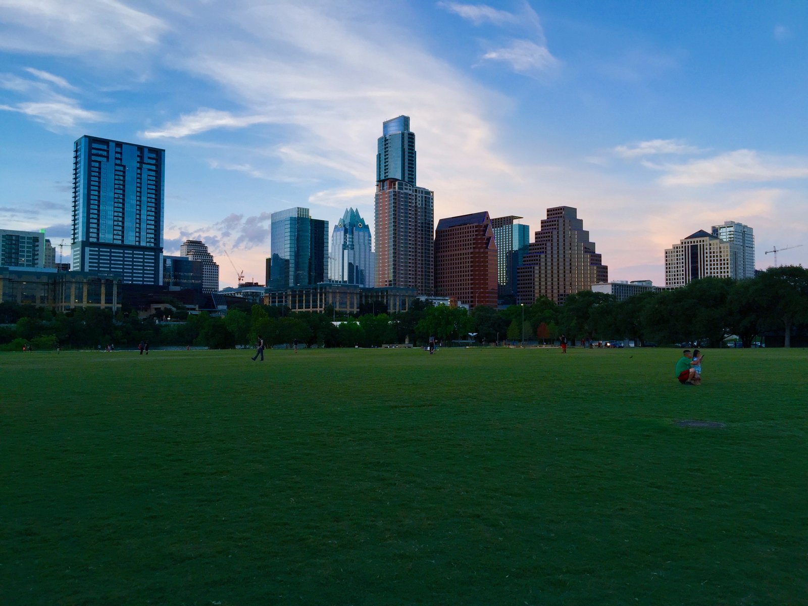 Austin skyline at dusk seen across the lawn of Auditorium Shores