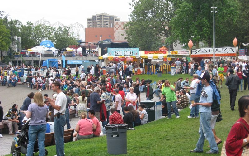 Visitors on a lawn among food stalls at the Bite of Seattle