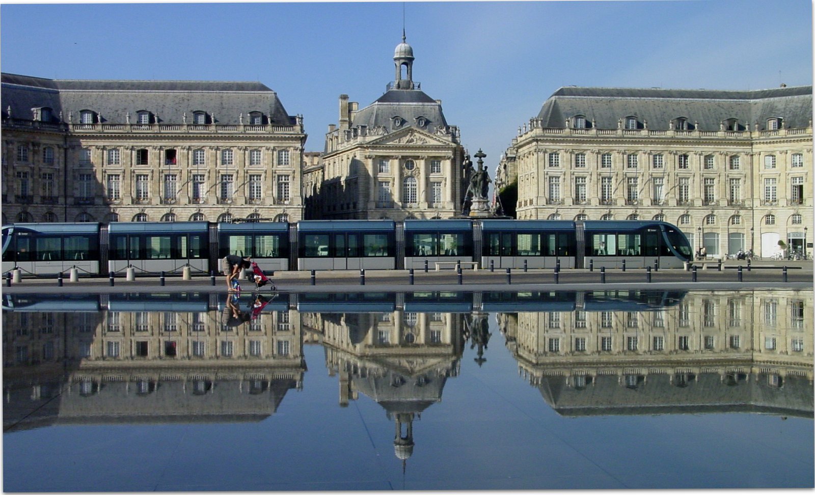 Place de la Bourse in Bordeaux mirrored in the Miroir d'eau with a tram passing