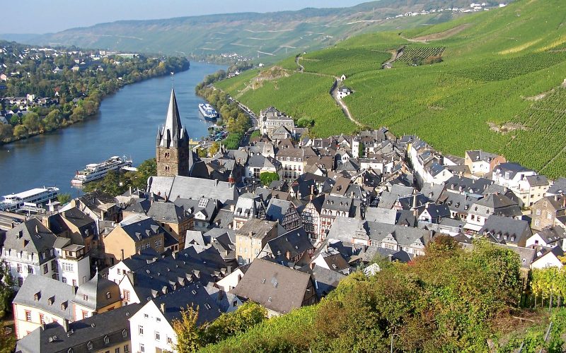 Bernkastel-Kues roofs and church tower beside the Moselle with steep vineyards behind