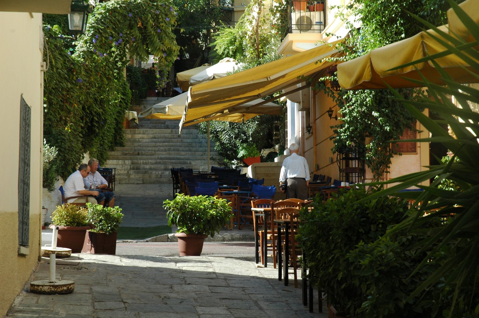 Shaded taverna terraces on a stepped lane in the Plaka district of Athens