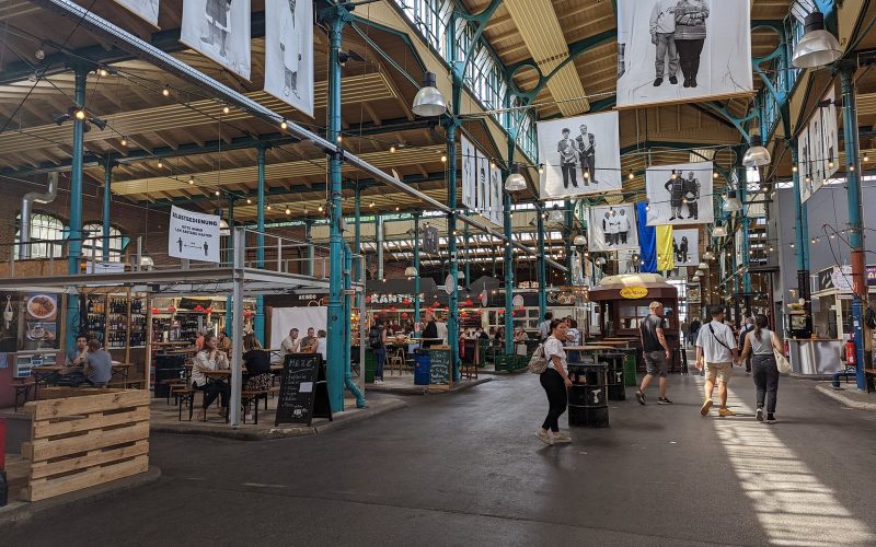 Light-filled iron market hall with food stalls at Markthalle Neun in Berlin Kreuzberg