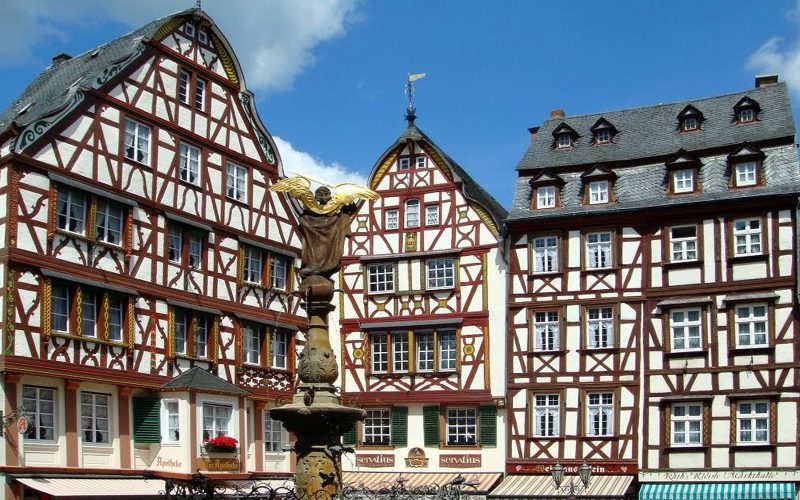 Half-timbered houses on the market square of Bernkastel-Kues under a blue sky