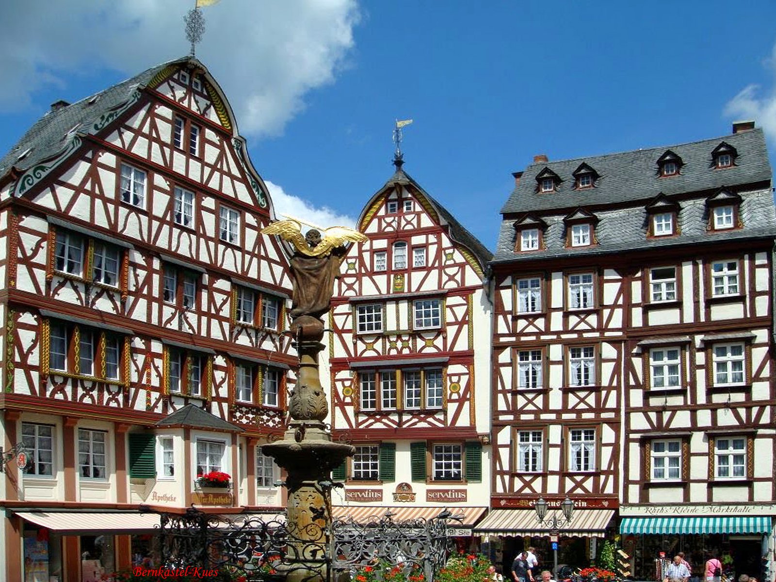 Half-timbered houses on the market square of Bernkastel-Kues under a blue sky