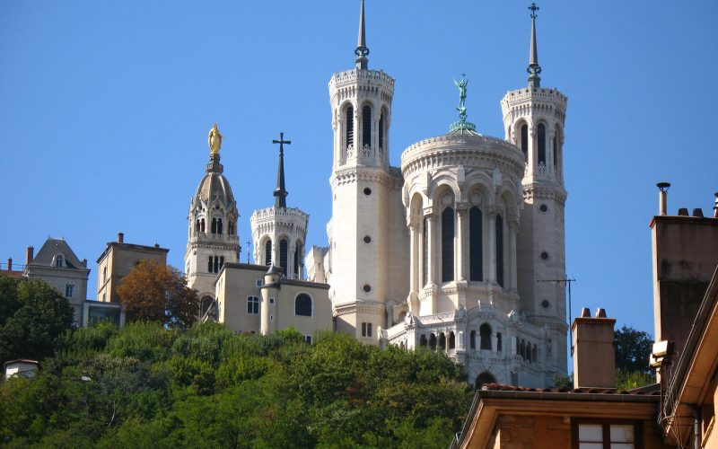 Towers of the Fourvière basilica above Lyon under a blue sky