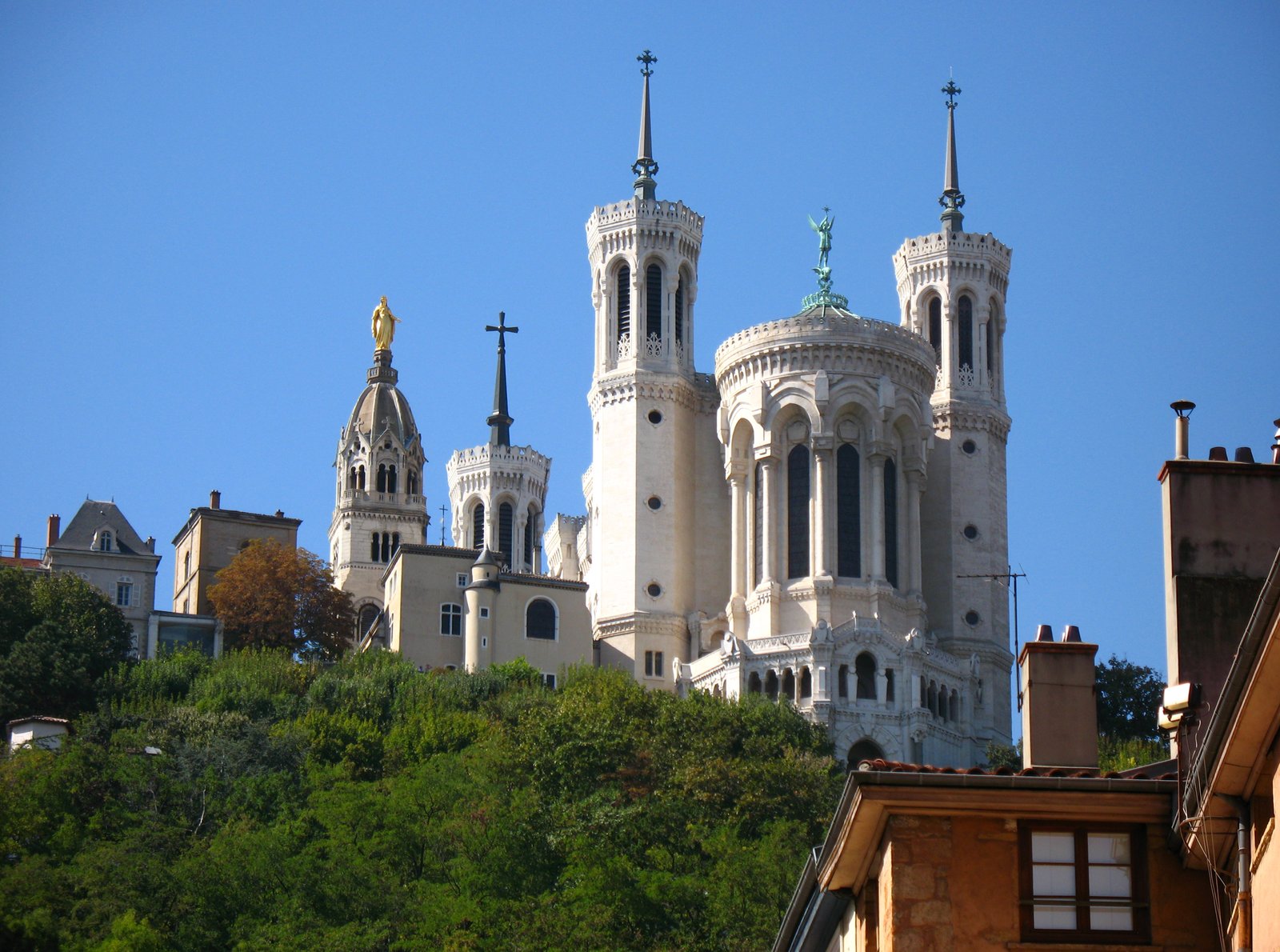 Towers of the Fourvière basilica above Lyon under a blue sky