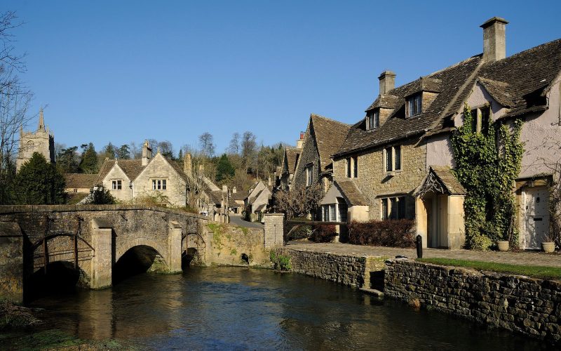 Stone bridge and honey-coloured cottages beside the river at Castle Combe