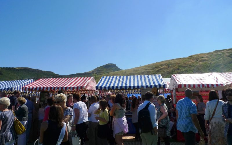 Crowds between striped food tents at the Foodies Festival in Edinburgh