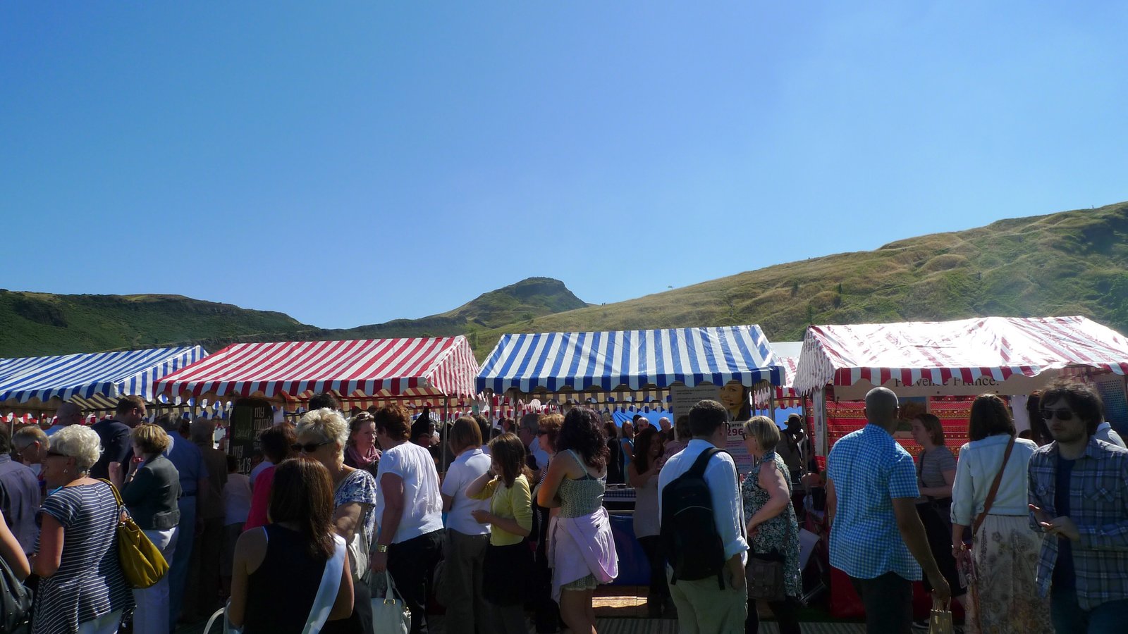 Crowds between striped food tents at the Foodies Festival in Edinburgh