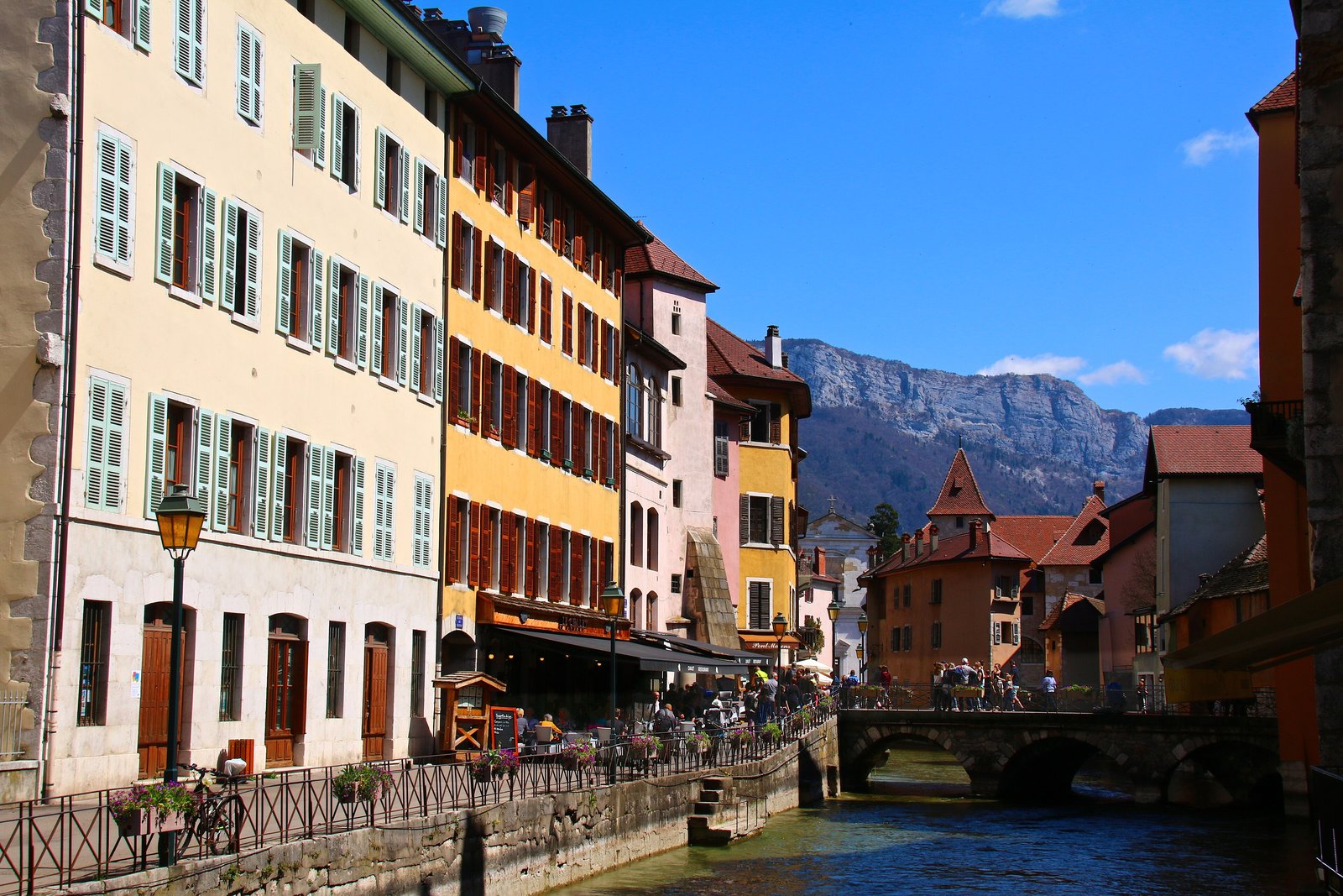 Canal lined with colourful houses in old Annecy with the Alps behind