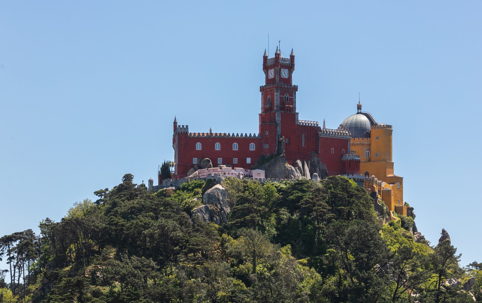 Pena Palace on its wooded hilltop in Sintra under a clear sky