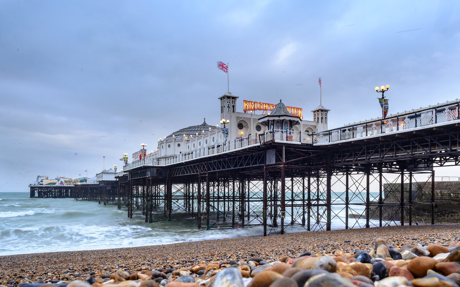Brighton Palace Pier on its iron legs above a pebble beach