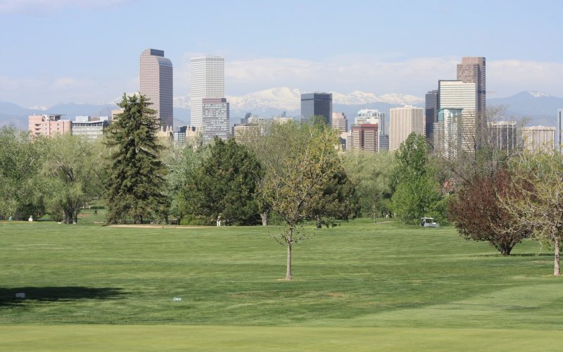 Denver skyline with Rocky Mountains behind City Park