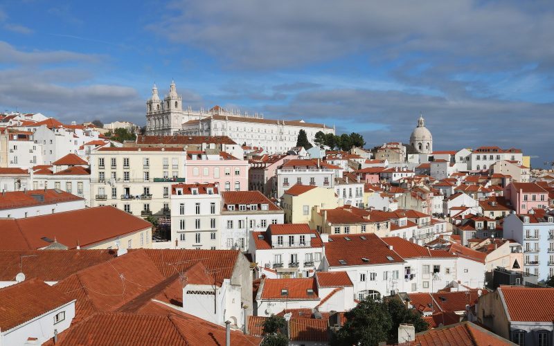 Terracotta rooftops of Alfama in Lisbon with the Tagus beyond