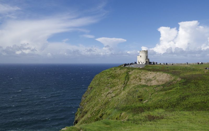 Green headland and O'Brien's Tower above the Atlantic at the Cliffs of Moher