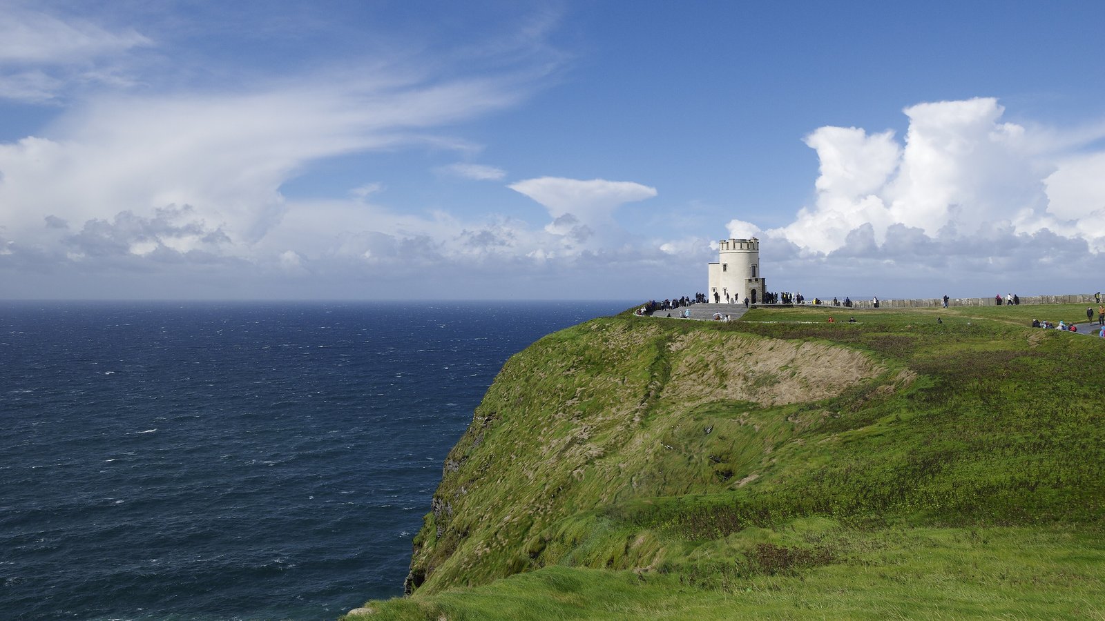 Green headland and O'Brien's Tower above the Atlantic at the Cliffs of Moher