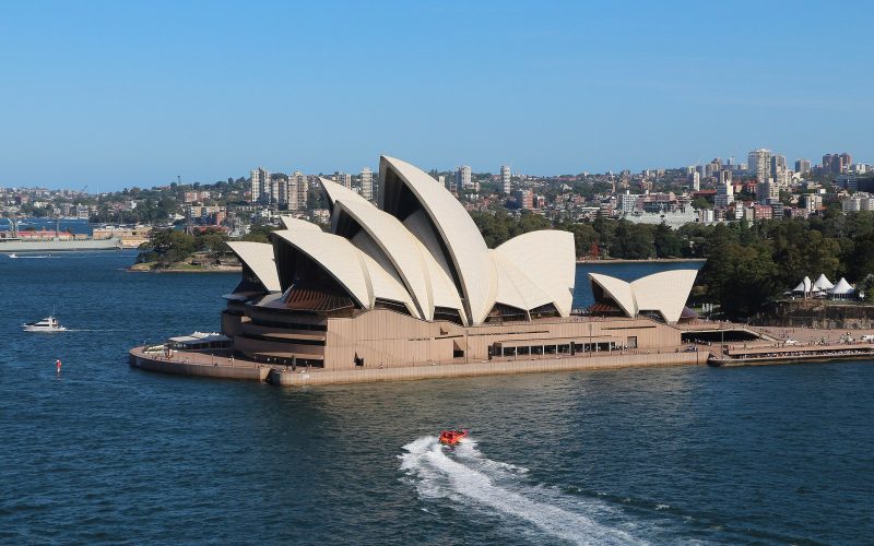 Sydney Opera House on the harbour under a blue sky
