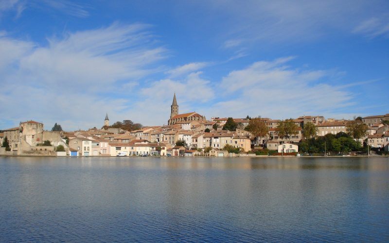 Castelnaudary town and church tower reflected in the Grand Bassin of the Canal du Midi