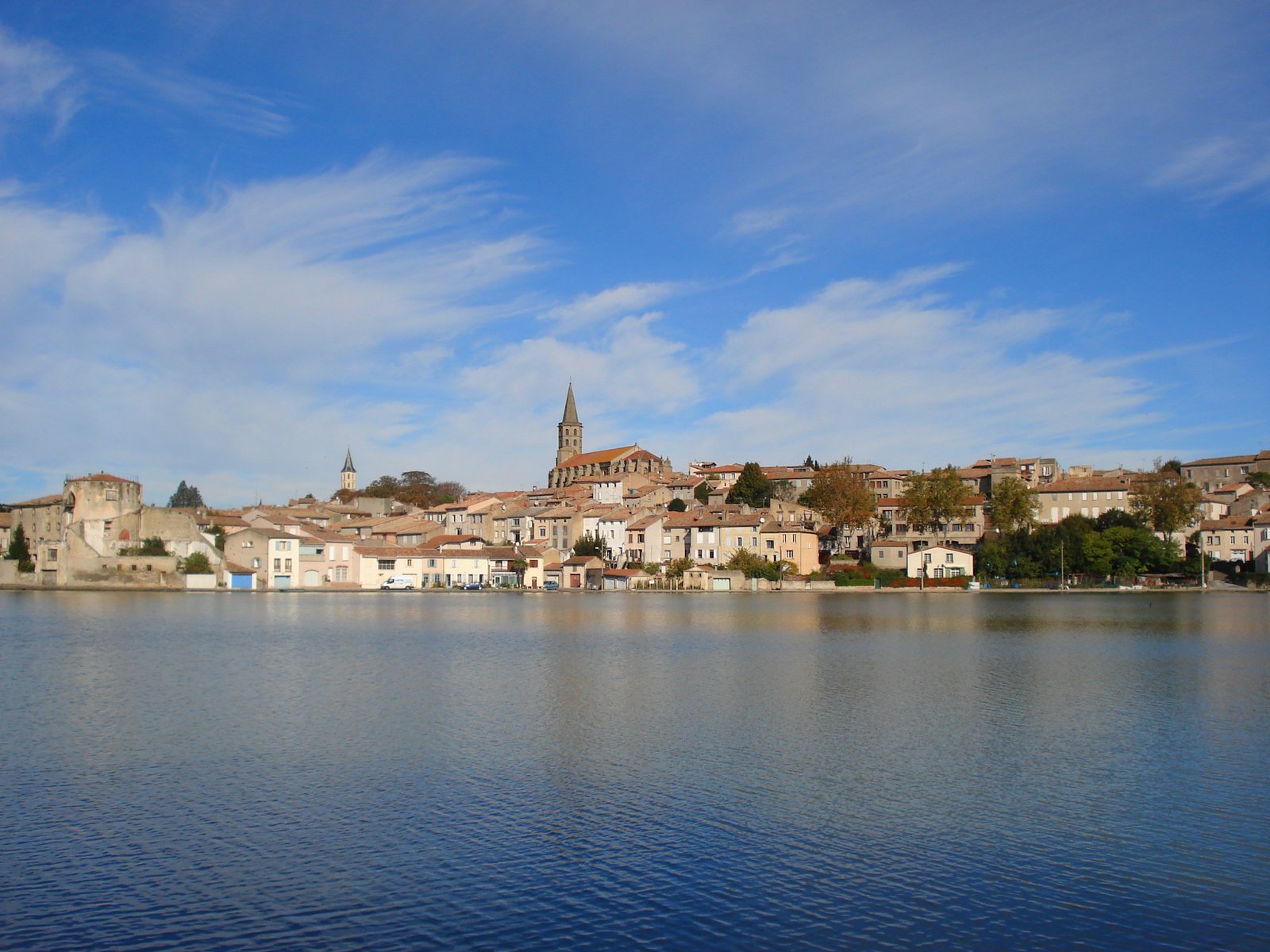 Castelnaudary town and church tower reflected in the Grand Bassin of the Canal du Midi