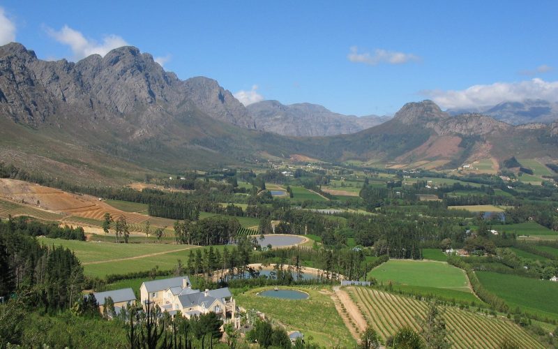 Franschhoek valley with vineyards and an estate below rugged mountains