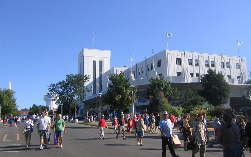 White exhibition building and visitors on an avenue of the Minnesota State Fair grounds