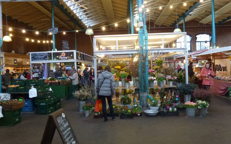 Market hall interior with stalls under string lights in Markthalle Neun, Berlin